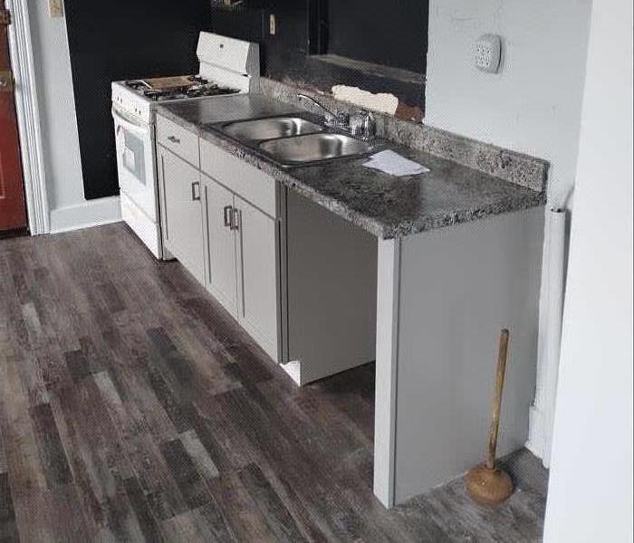 Fully renovated kitchen with new cabinets and fresh flooring.