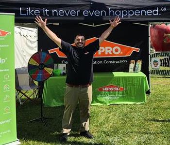 A SERVPRO employee stands outside a SERVPRO tent at an event.