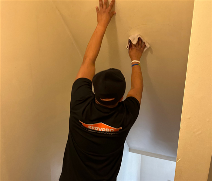 SERVPRO employee wipes soot off of walls